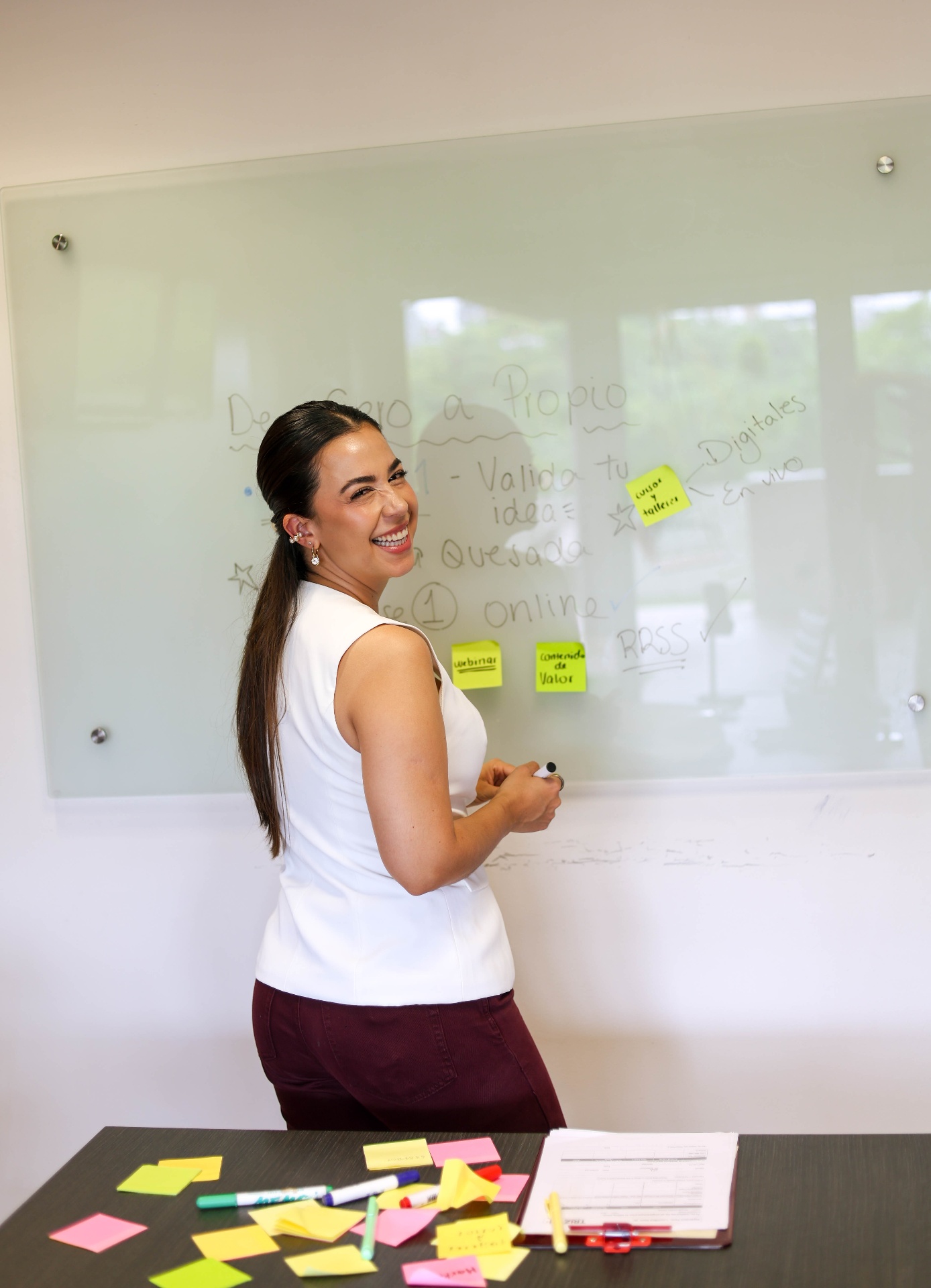 Karla Quesada frente a una pizarra con las bases de De Cero A Propio